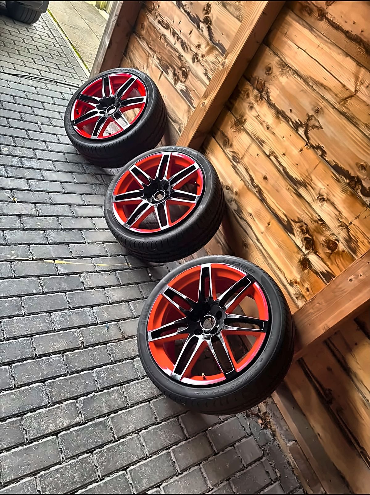 Custom two-tone alloy wheels in gloss black and candy red